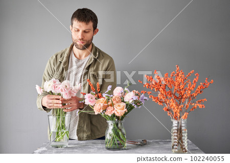 Portrait of a Male florist. Flowers bunch, set for home. Fresh cut flowers for decoration home. European floral shop. Delivery fresh cut flower. Portrait of a Male florist. Flowers bunch, set for home. Fresh cut flowers for decoration home. European floral shop. Delivery fresh cut flower. 102240055