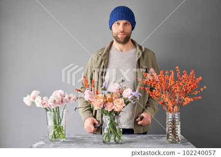 Portrait of a Male florist. Flowers bunch, set for home. Fresh cut flowers for decoration home. European floral shop. Delivery fresh cut flower. Portrait of a Male florist. Flowers bunch, set for home. Fresh cut flowers for decoration home. European floral shop. Delivery fresh cut flower. 102240057