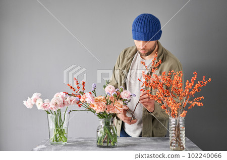 Portrait of a Male florist. Flowers bunch, set for home. Fresh cut flowers for decoration home. European floral shop. Delivery fresh cut flower. Portrait of a Male florist. Flowers bunch, set for home. Fresh cut flowers for decoration home. European floral shop. Delivery fresh cut flower. 102240066