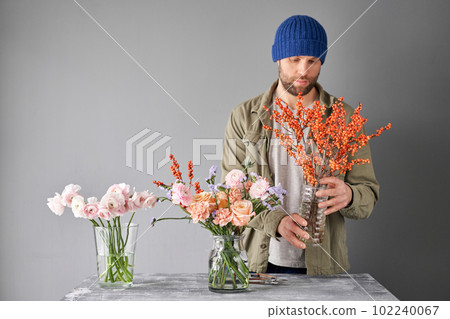 Portrait of a Male florist. Flowers bunch, set for home. Fresh cut flowers for decoration home. European floral shop. Delivery fresh cut flower. Portrait of a Male florist. Flowers bunch, set for home. Fresh cut flowers for decoration home. European floral shop. Delivery fresh cut flower. 102240067