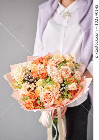 Beautiful large bouquet of mixed flowers without packaging. Handsome fresh bouquet in woman hand. Small flower shop and Flowers delivery. 102240142