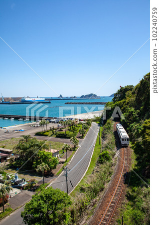 日南線 Kiha 40 通勤列車，在金色的晨光中照亮宮崎縣日南市油津港的岩石海灘 102240759