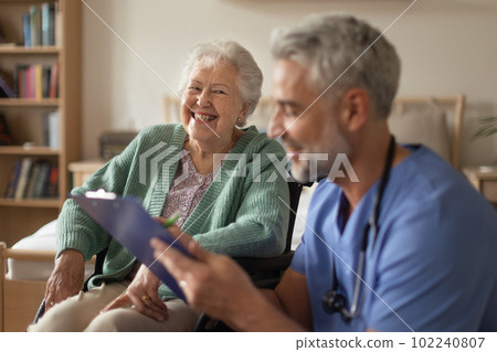 Caregiver doing regular check-up of senior woman in her home. 102240807