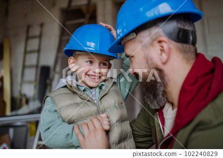 Father and his little son cuddling in their unfinished house. 102240829