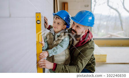 Father and his little son working on their unfinished house. Father and his little son working on their unfinished house. 102240830