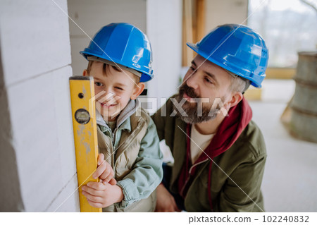 Father and his little son working on their unfinished house. Father and his little son working on their unfinished house. 102240832