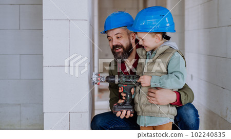 Father and his little son working on their unfinished house. Father and his little son working on their unfinished house. 102240835