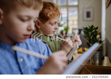 Close up of students writing notes in to their notepads. 102240880