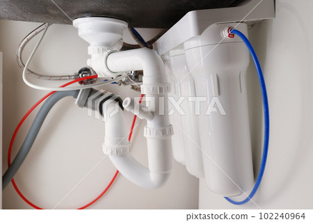 House water filtration system, Reverse osmosis. Installation or replacement cartridges of water purification filters under kitchen sink in cupboard. Clear water concept. World Water Day 102240964