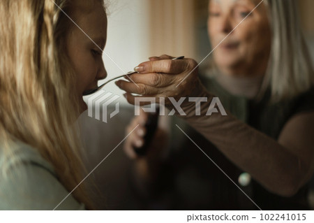 Senior woman taking care of her sick granddaughter. 102241015