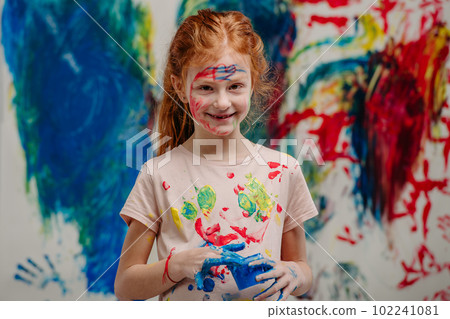 Portrait of happy kid with finger colours and painted t-shirts, studio shoot. Portrait of happy kid with finger colours and painted t-shirts, studio shoot. 102241081
