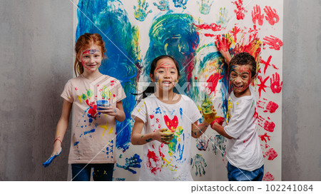 Portrait of happy kids with finger colours and painted t-shirts, studio shoot. Portrait of happy kids with finger colours and painted t-shirts, studio shoot. 102241084