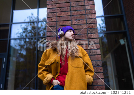 Young woman listening music outdoor, in a city. Young woman listening music outdoor, in a city. 102241231