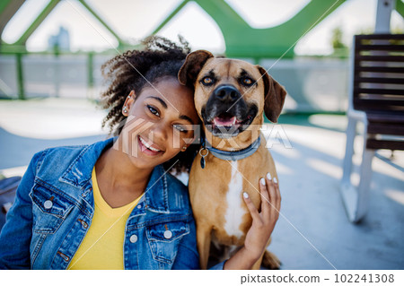 Portrait of happy multiracial girl with her dog. Concept of relationship between dog and teenager, everyday life with pet. Portrait of happy multiracial girl with her dog. Concept of relationship between dog and teenager, everyday life with pet. 102241308