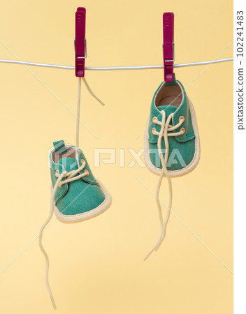 Tiny baby shoes hanging on the clothesline. Newborn concept Tiny baby shoes hanging on the clothesline. Newborn concept 102241483