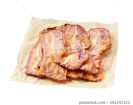 fried bacon strips on a parchment isolated on white background. 102242321