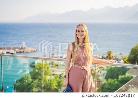 Woman tourist in Old town Kaleici in Antalya. Turkiye. Panoramic view of Antalya Old Town port, Taurus mountains and Mediterrranean Sea, Turkey Woman tourist in Old town Kaleici in Antalya. Turkiye. Panoramic view of Antalya Old Town port, Taurus mountains and Mediterrranean Sea, Turkey 102242817