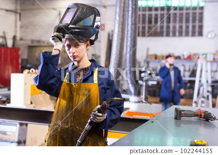 Woman welder in metalworking workshop 102244155