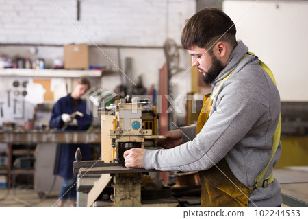 Craftsman working on drilling machine Craftsman working on drilling machine 102244553