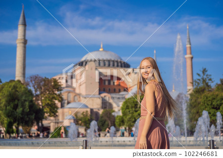 Woman enjoy beautiful view on Hagia Sophia Cathedral, famous islamic Landmark mosque, Travel to Istanbul, Turkey. Sunny day architecture and Hagia Sophia Museum, in Eminonu, istanbul, Turkey. Turkiye 102246681