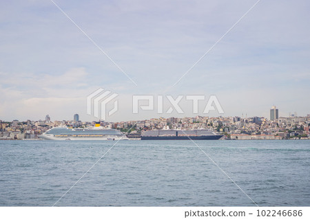 Huge cruise ship docked at terminal of Galataport, located along shore of Bosphorus strait, in Karakoy neighbourhood, with Galata tower in the background 102246686
