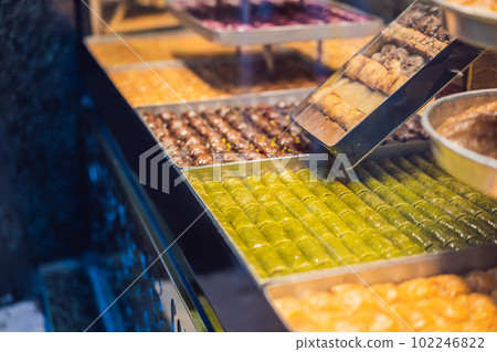 Traditional oriental sweet pastry cookies, nuts, dried fruits, pastilles, marmalade, Turkish desert with sugar, honey and pistachio, in display at a street food market Traditional oriental sweet pastry cookies, nuts, dried fruits, pastilles, marmalade, Turkish desert with sugar, honey and pistachio, in display at a street food market 102246822