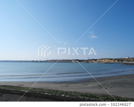 Sunlit sandy beach and coast and breakwater Sunlit sandy beach and coast and breakwater 102246827