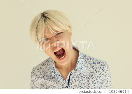Emotional lady with blonde hair screams with wide open mouth Emotional lady with blonde hair screams with wide open mouth 102246914