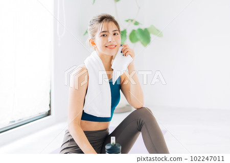 A woman sweating with a towel A woman sweating with a towel 102247011