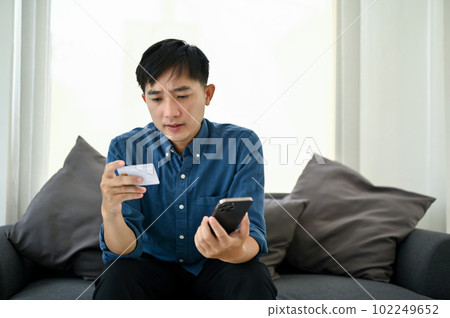 Stressed Asian man having a problem with his mobile banking application Stressed Asian man having a problem with his mobile banking application 102249652