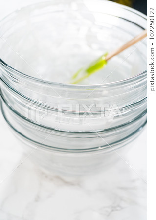 Dirty glass mixing bowls stacked on the kitchen counter after baking. 102250122