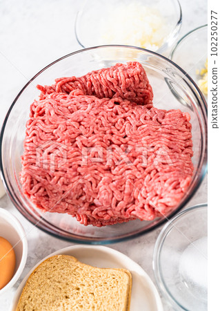Measured ingredients in glass mixing bowls to make meatloaf. 102250277