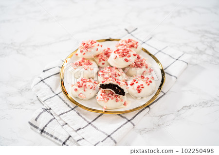 Freshly baked peppermint white chocolate cookies on a white plate. 102250498