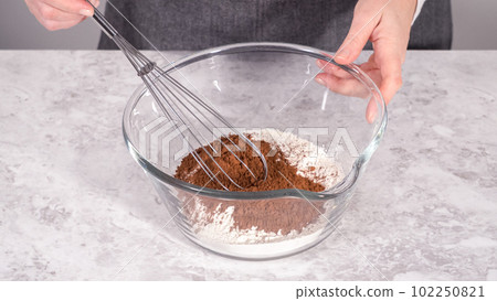 Step by step. Mixing ingredients in a glass mixing bowl to prepare red velvet bundt cake. Step by step. Mixing ingredients in a glass mixing bowl to prepare red velvet bundt cake. 102250821