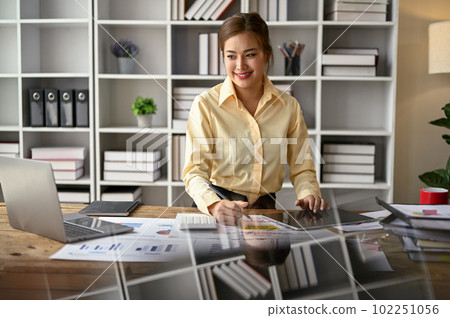 A beautiful Asian businesswoman looking at laptop screen and working in the office. A beautiful Asian businesswoman looking at laptop screen and working in the office. 102251056
