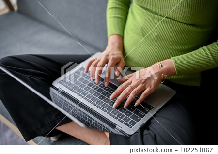 close-up image of a young Asian woman typing on keyboard, using her laptop 102251087