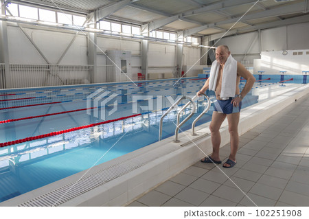 A 70-year-old pensioner is resting, swimming, recovering in the pool with clear and blue water in the hotel. A 70-year-old pensioner is resting, swimming, recovering in the pool with clear and blue water in the hotel. 102251908