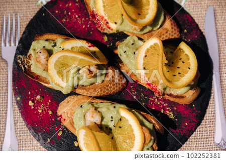 Top view of bruschetta with guacamole and shrimps. Delicious food in restaurant 102252381