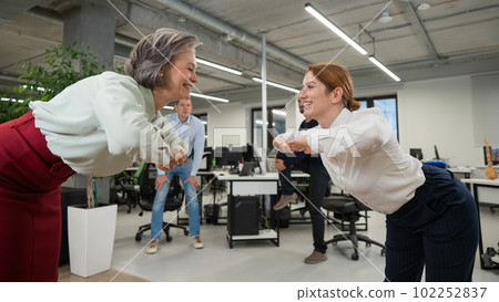 Four office workers warm up during a break. Employees do fitness exercises at the workplace.  102252837