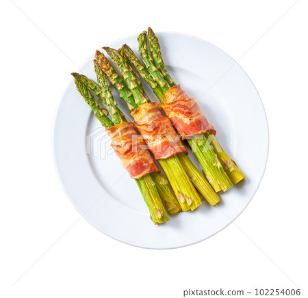 Plate with baked appetizer, bundle of green asparagus wrapped in bacon isolated on a white background. Top view. Plate with baked appetizer, bundle of green asparagus wrapped in bacon isolated on a white background. Top view. 102254006