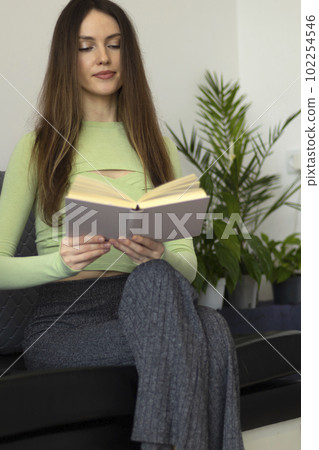 A beautiful young woman reading a book in a restaurant. In a book cafe. 102254546
