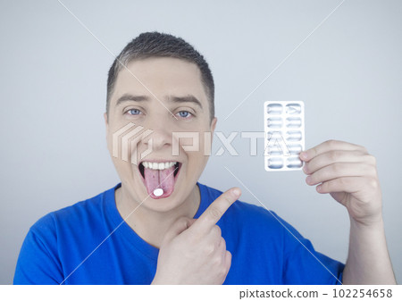 Oral probiotics. A man puts a pill with beneficial bacteria on his tongue. Dysbacteriosis and imbalance of beneficial and harmful microorganisms in the mouth. Increase immunity and improve health. Oral probiotics. A man puts a pill with beneficial bacteria on his tongue. Dysbacteriosis and imbalance of beneficial and harmful microorganisms in the mouth. Increase immunity and improve health. 102254658