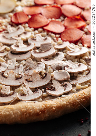 Big uncooked pizza with variety of toppings 102254769