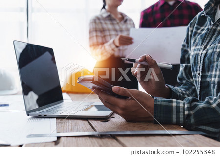 Architect and Engineer working with blueprints for architectural plan, engineer sketching a construction project, green energy concept Architect and Engineer working with blueprints for architectural plan, engineer sketching a construction project, green energy concept 102255348