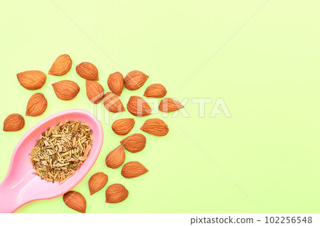 Plastic spoon with spices and apricot kernels for cooking,drinks,baking on lime Plastic spoon with spices and apricot kernels for cooking,drinks,baking on lime 102256548