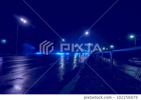 Night empty freeway highway with wet asphalt and shining blue lights Night empty freeway highway with wet asphalt and shining blue lights 102256878