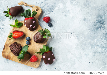 Gourmet chocolate covered strawberries on the light background. Top view with copy space Gourmet chocolate covered strawberries on the light background. Top view with copy space 102257574