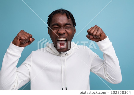 cute surprised african 20s man with dreadlocks on background with copy space 102258364