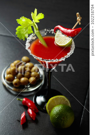 Bloody Mary cocktail with celery, lime, red pepper, and green olives. 102258784