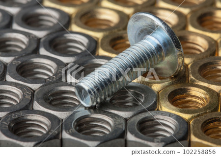 Metallic hex nuts and a fastener bolt with rivet, industrial background 102258856